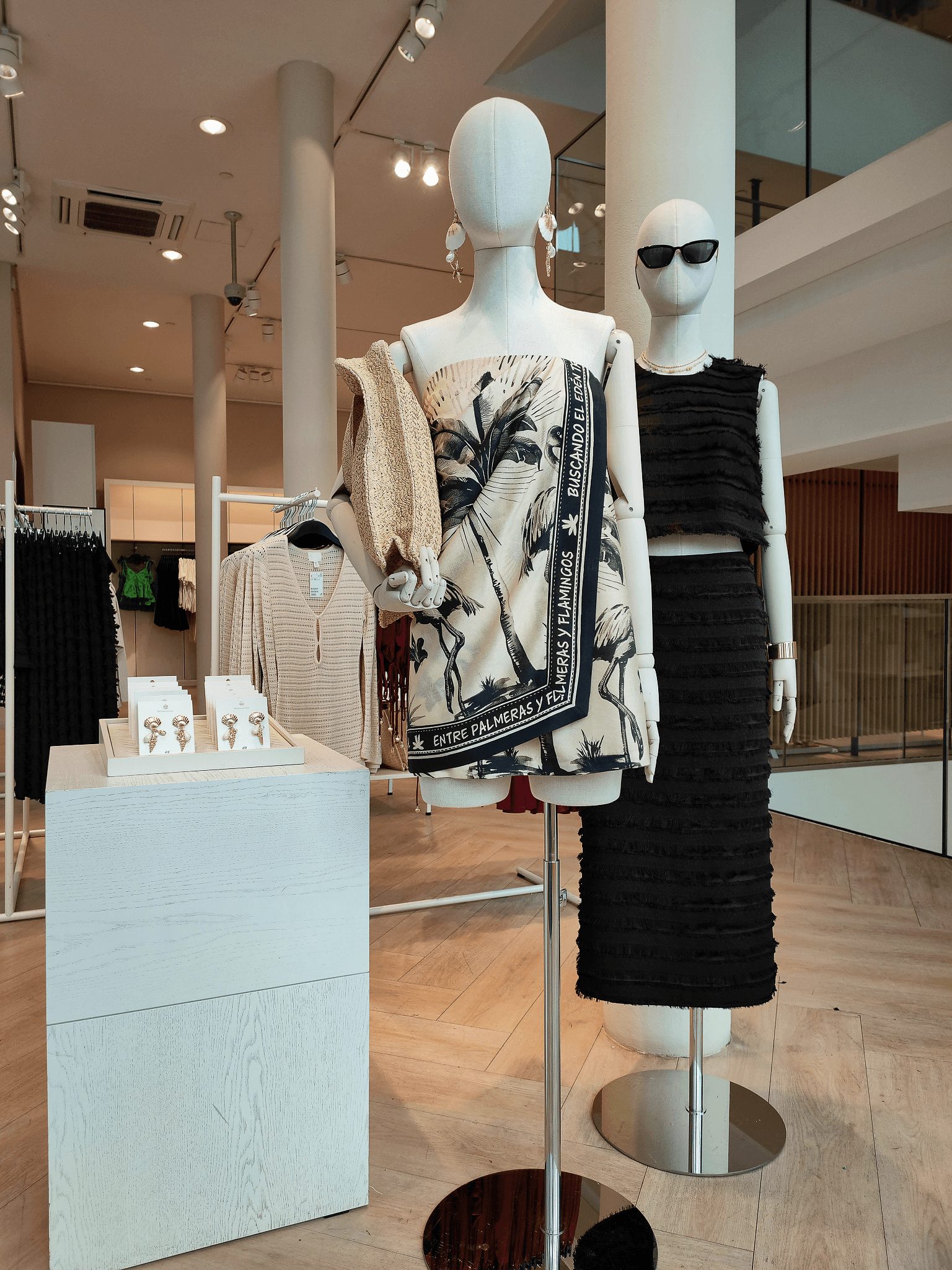 Palm-print scarf and textured black dress mannequins