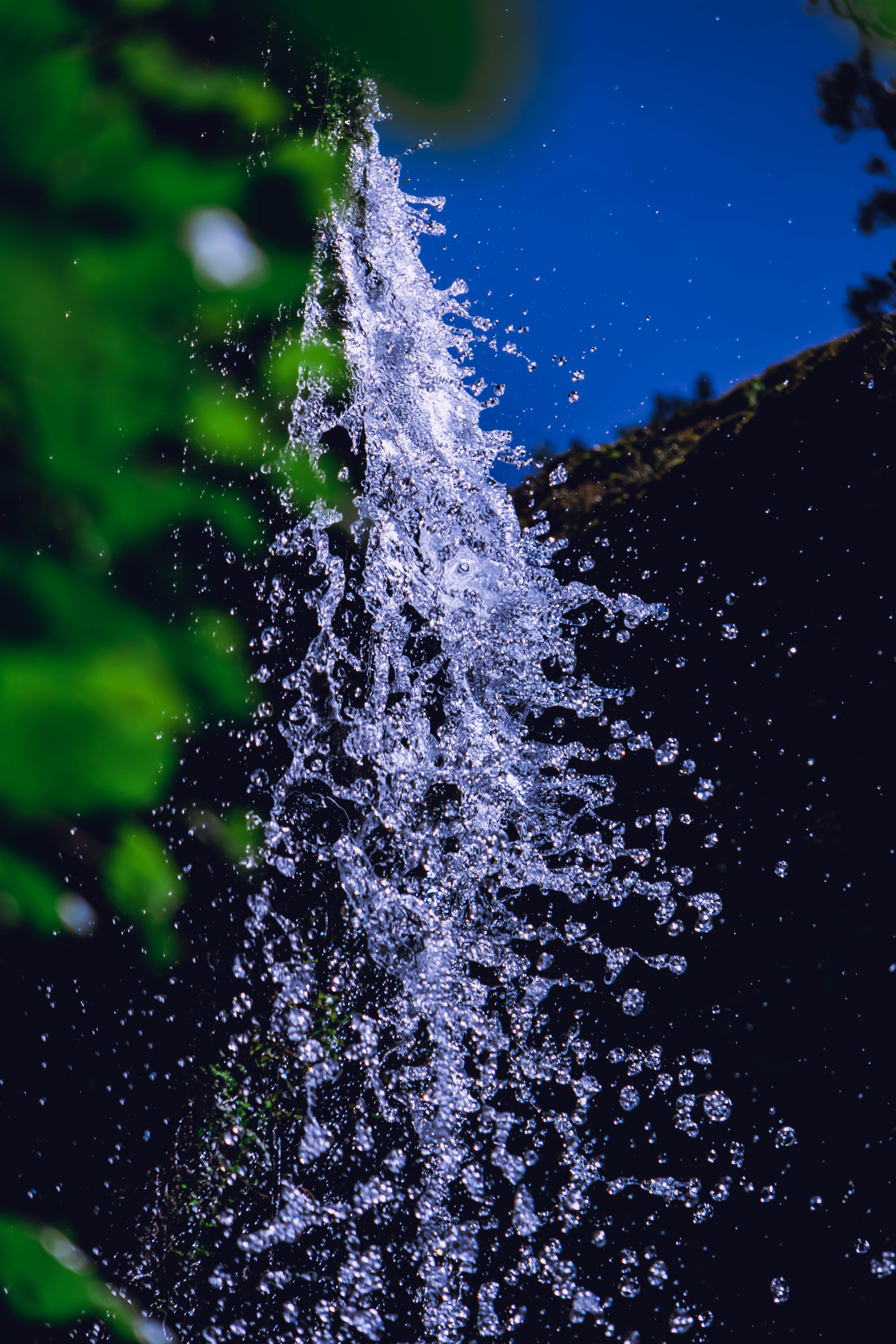 Water spray against blue sky, fine droplets