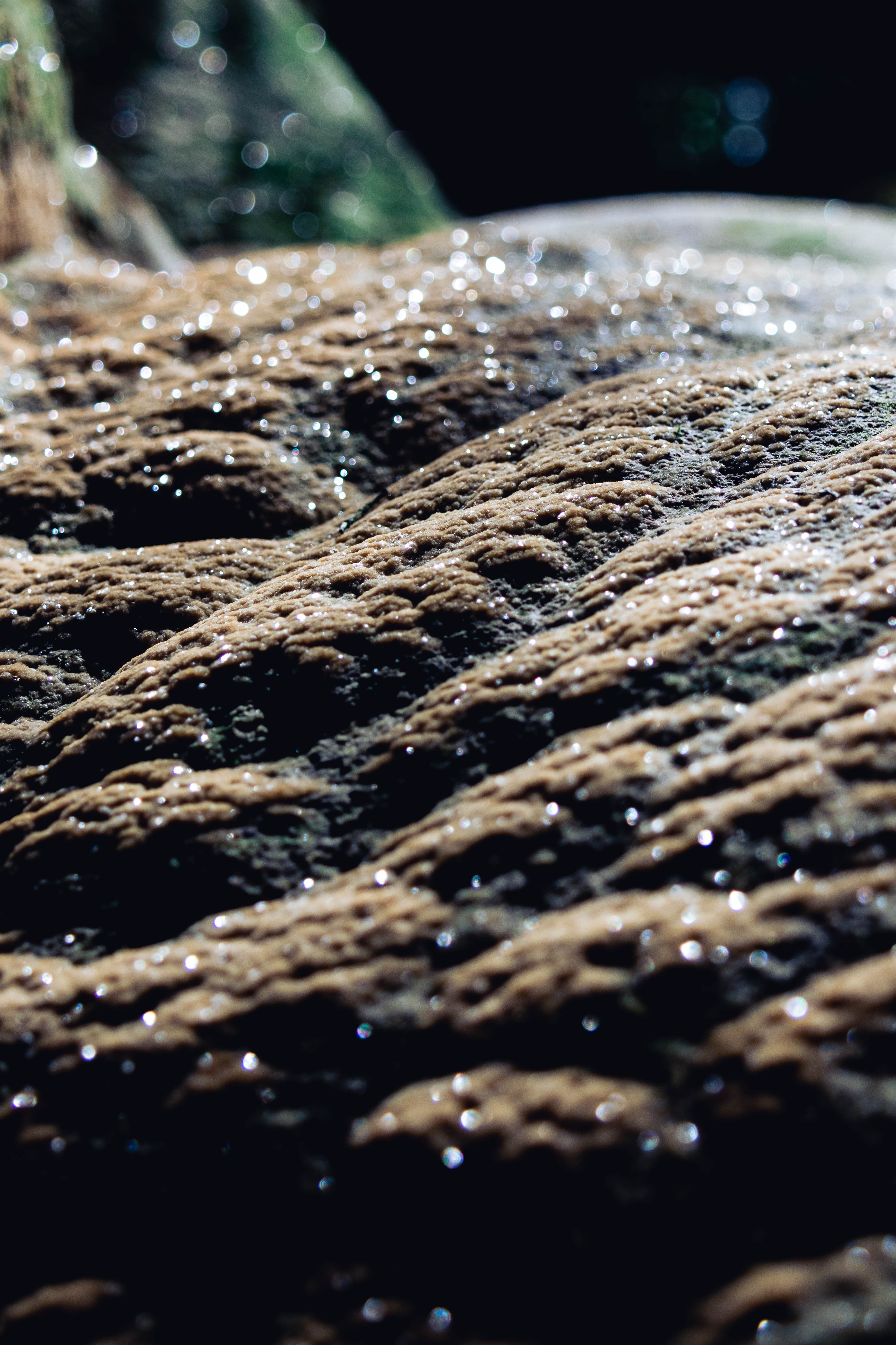 Water flowing over textured rock, macro