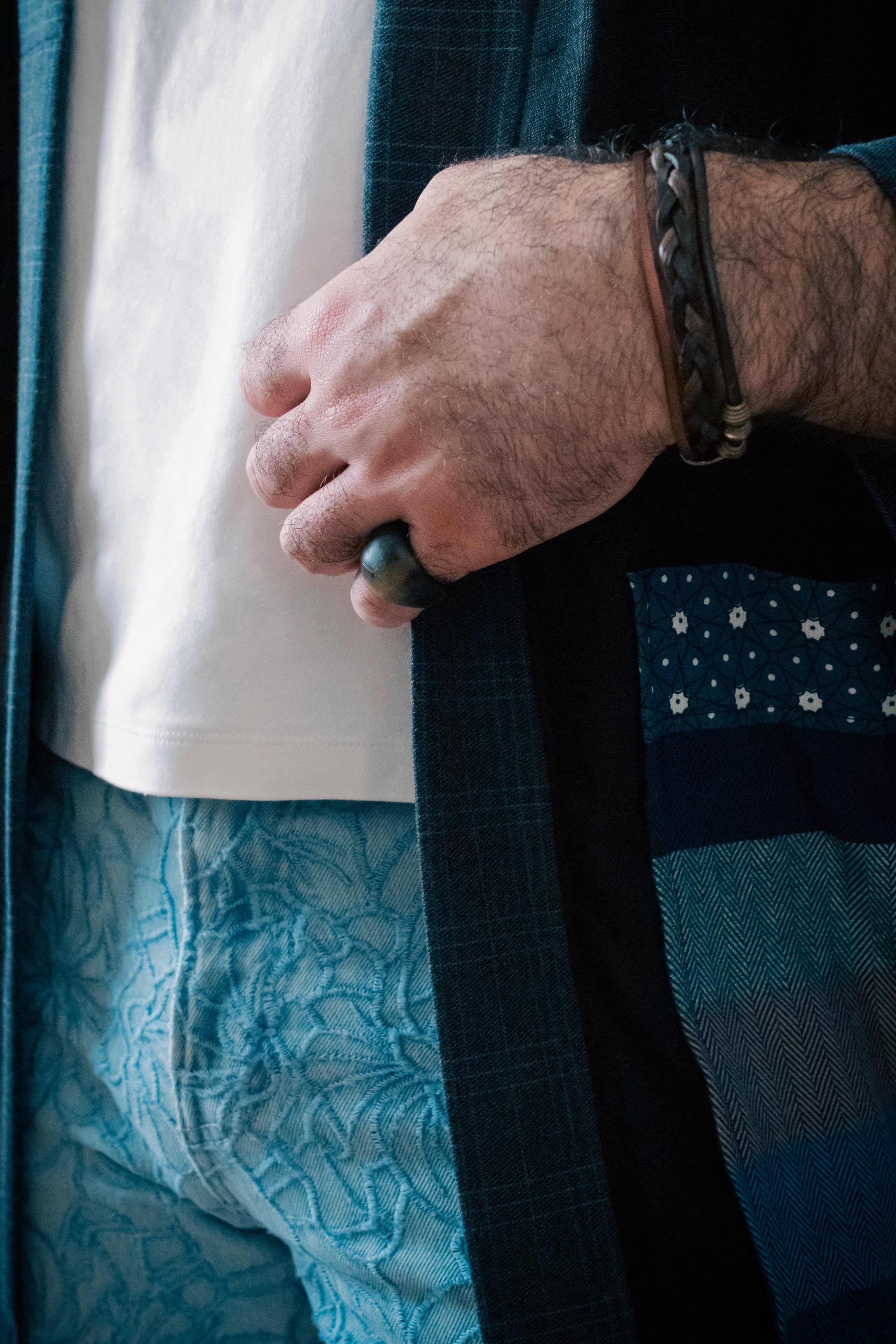 Hand on layered denim and check jacket, beige tee underneath